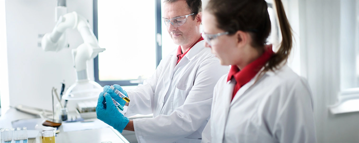 Mitarbeiterin und Mitarbeiter beproben und testen flüssige Abfälle im Labor