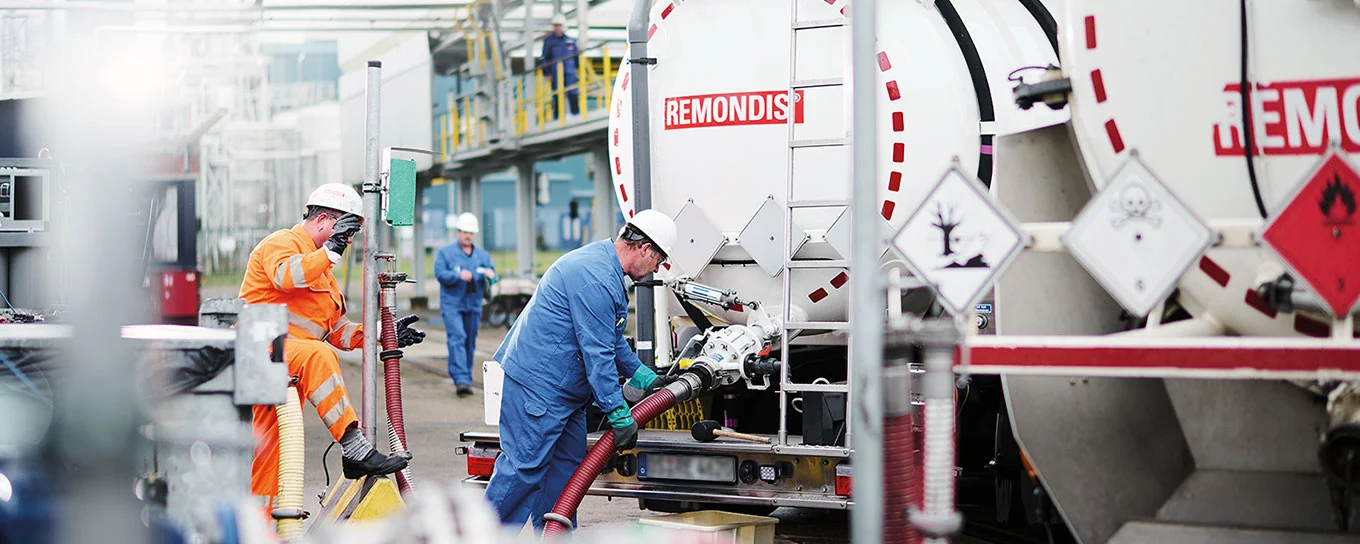 Ein Mitarbeiter schließt einen Schlauch an einen Saugwagen an.