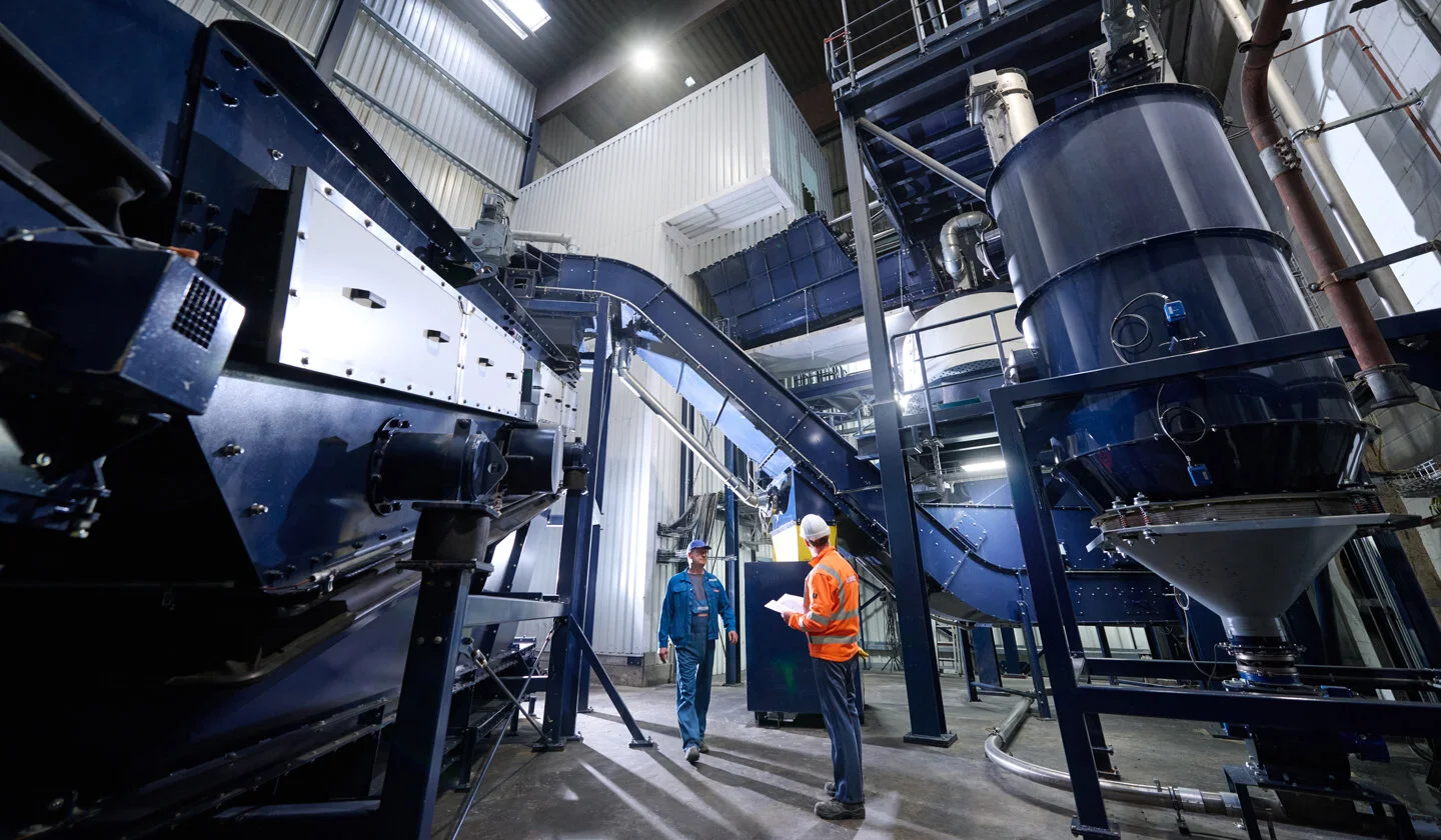 Zwei Mitarbeiter stehen in einer Industrieanlage